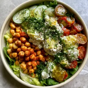 Close-up of golden-roasted chickpeas with smoked paprika dusting on a Mediterranean feta salad.