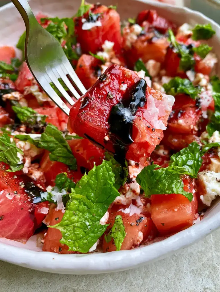 Balsamic glaze drizzled in thin ribbons over a watermelon and mint salad.