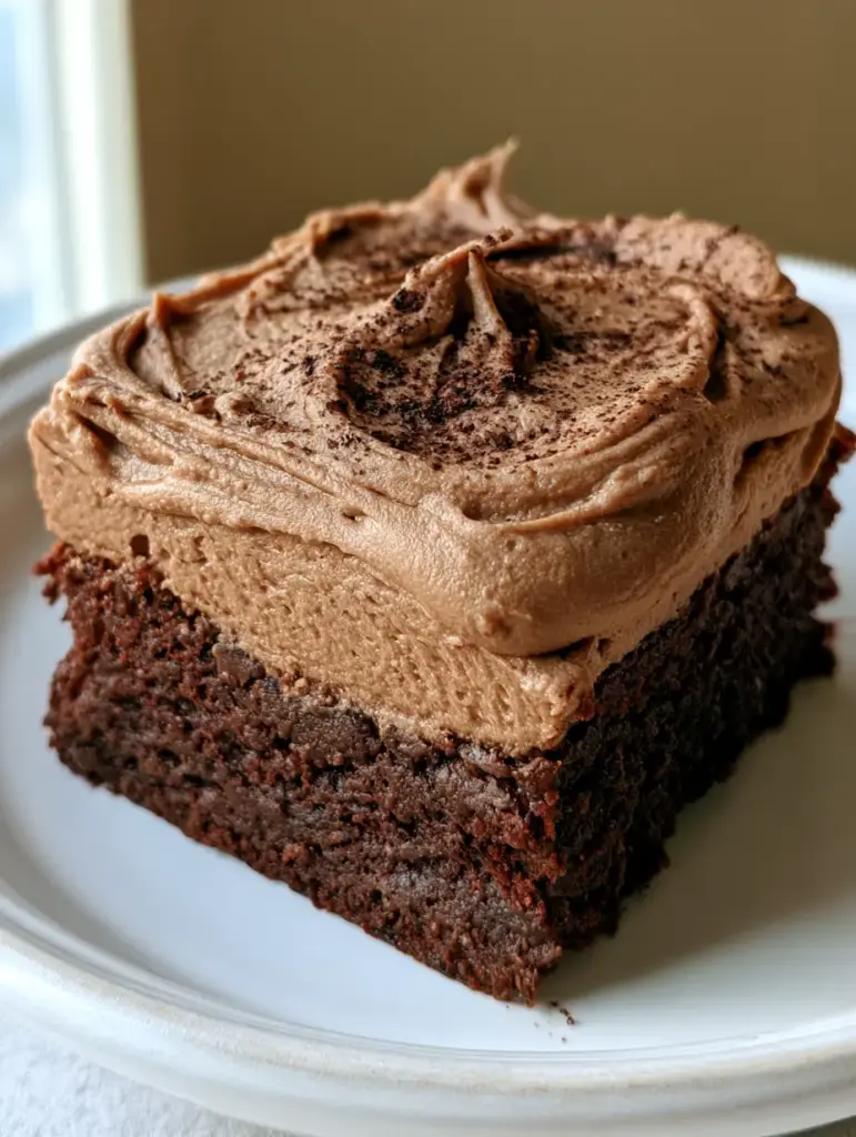 A handheld smartphone photo of Coffee Brownies sitting on a neutral beige background.