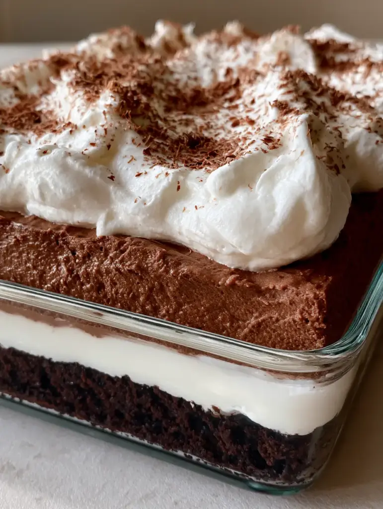 Close up of the fluffy whipped cream topping and chocolate shavings on the No-Bake Brownie Layer Cake.