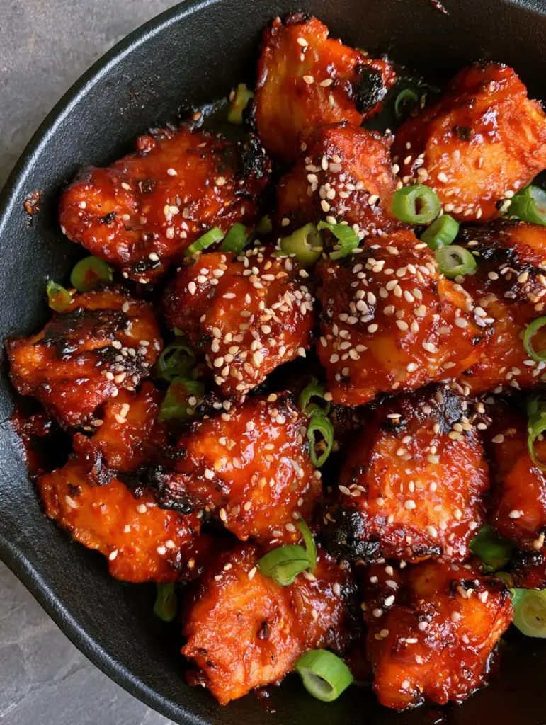 Korean Gochujang Chicken: The Ultimate Glossy and Spicy Skillet Dinner 1 Close-up of glossy Korean Gochujang Chicken showing the sticky texture of the spicy glaze and sesame seeds.