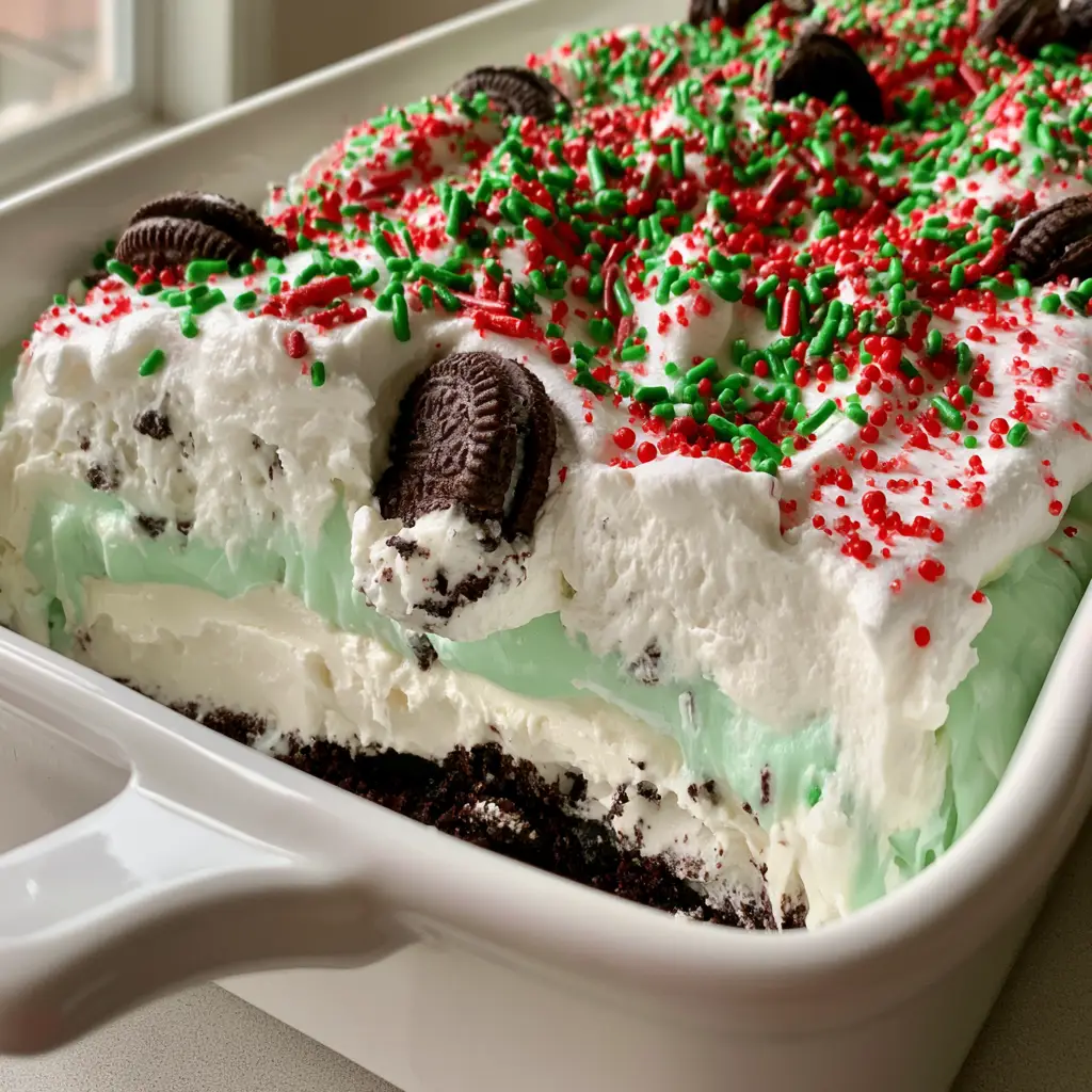 Side view of the Christmas Oreo Lasagna showing the foundation of crushed dark chocolate sandwich cookie crumbs.