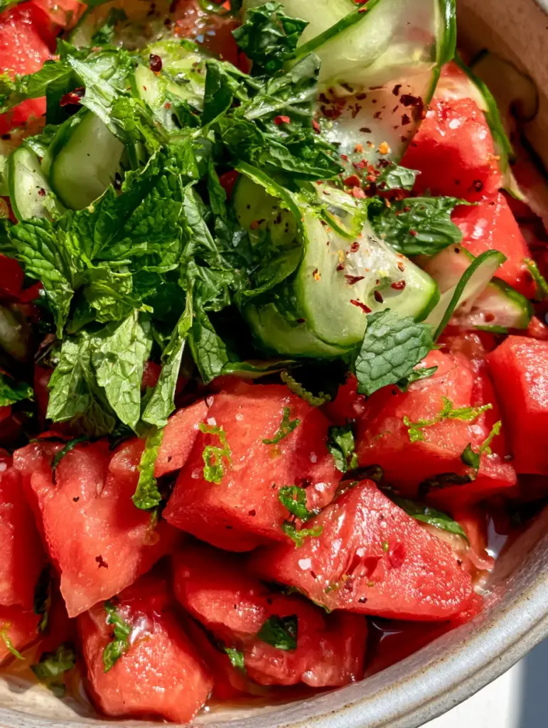 Watermelon Recipes: The Ultimate Honey-Lime and Persian Cucumber Summer Salad 2 Close-up of jagged ruby-red watermelon cubes glistening with lime juice and honey drizzle. (watermelon recipes)