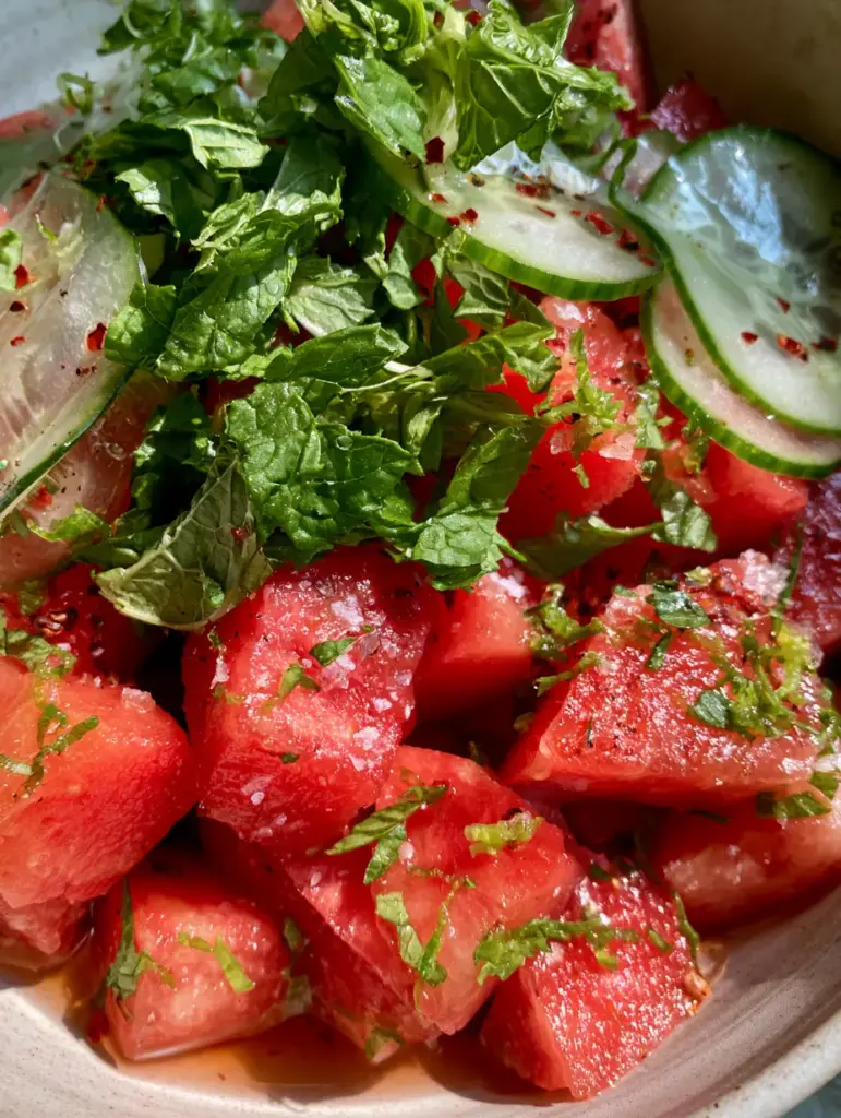Watermelon Recipes: The Ultimate Honey-Lime and Persian Cucumber Summer Salad 1 Hand-torn mint leaves and translucent Persian cucumber slices over a watermelon salad.