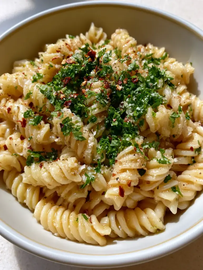 One Pot Garlic Butter Pasta: The Easiest 15-Minute Dinner 1 A centered shot of One Pot Garlic Butter Pasta in a white bowl with parmesan and chili flakes.