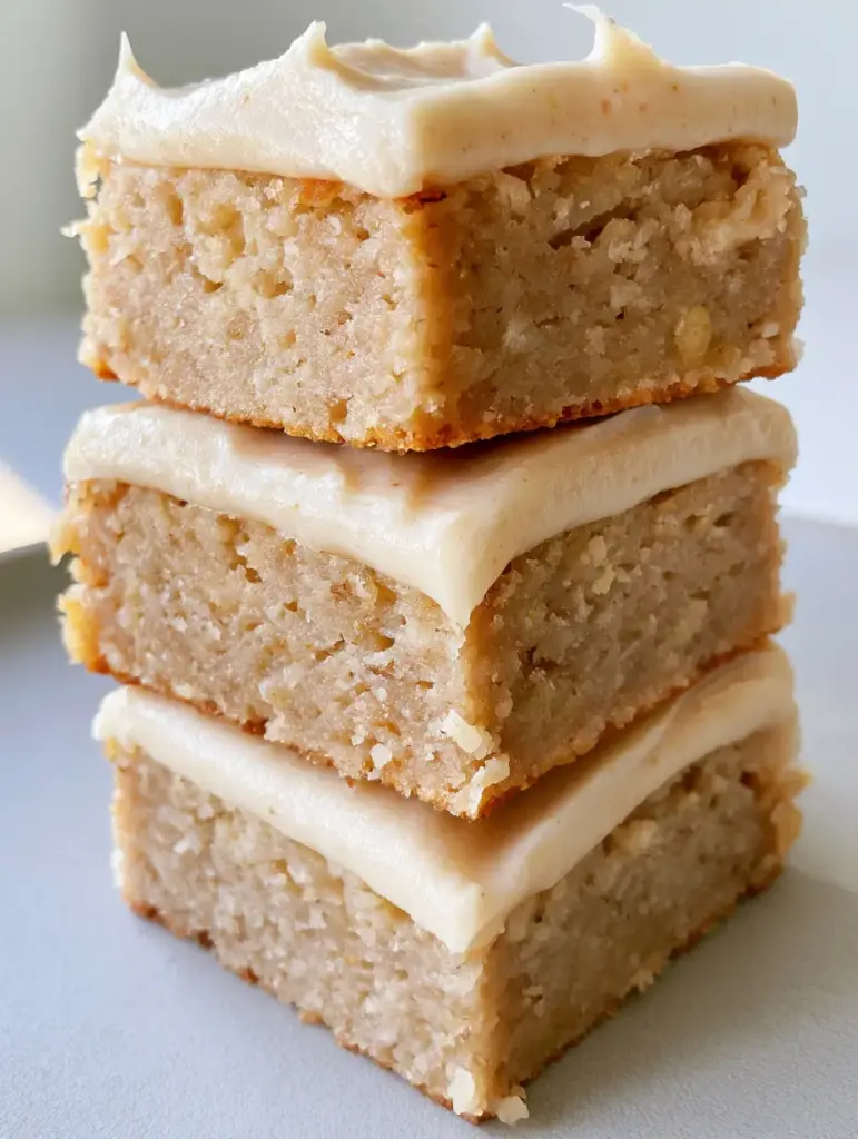 Banana Bread Brownies with Creamy Vanilla Frosting 2 Close up of a moist Banana Bread Brownie showing the dense blondie-style crumb and tiny banana flecks.
